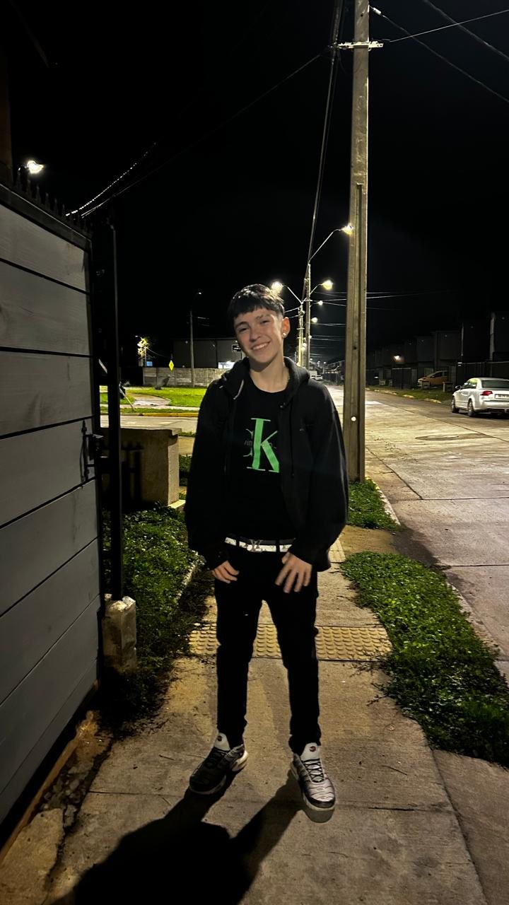 Facundo sonriendo en la calle, de noche